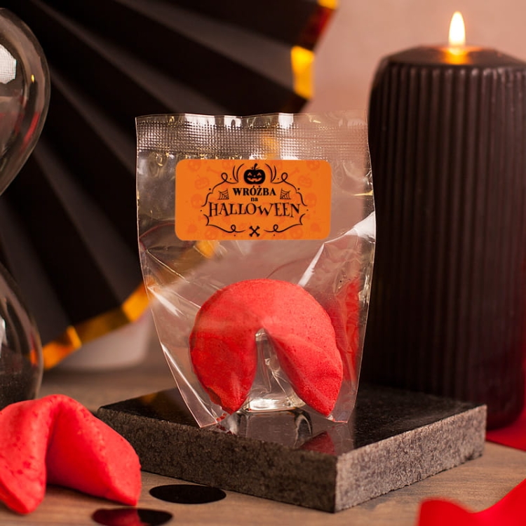 Chrupiące ciasteczko z wróżbą  na Halloween. Opakowanie ozdobione jest tematyczna etykietą, a samo ciasteczko ma wyjątkowy malinowy kolor.