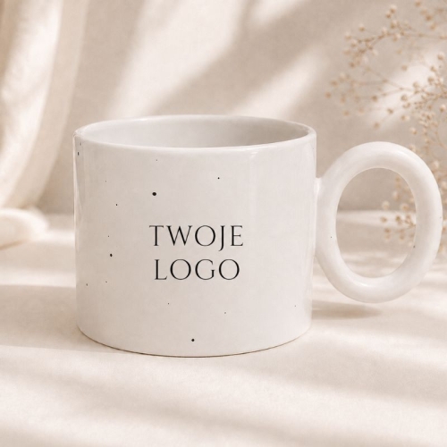 Biały kubek nakrapiany z logo firmy to elegancki gadżet reklamowy do biura i na wydarzenia firmowe.