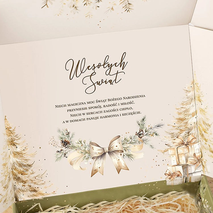 Wnętrze pudełka prezentowego zdobią świąteczne życzenia oraz elegancka grafika z kokardą, choinkami i prezentami.