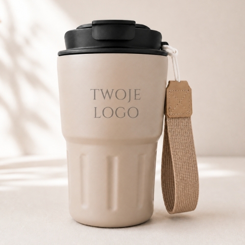 Beżowy kubek termiczny z paskiem i grawerem logo firmy to praktyczny gadżet reklamowy dla klientów i pracowników.