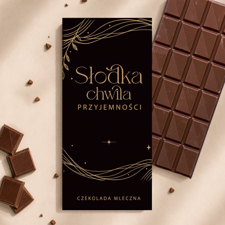 Czekolada mleczna w eleganckim czarnym opakowaniu z napisem „Słodka chwila przyjemności”, prezent na Boże Narodzenie.