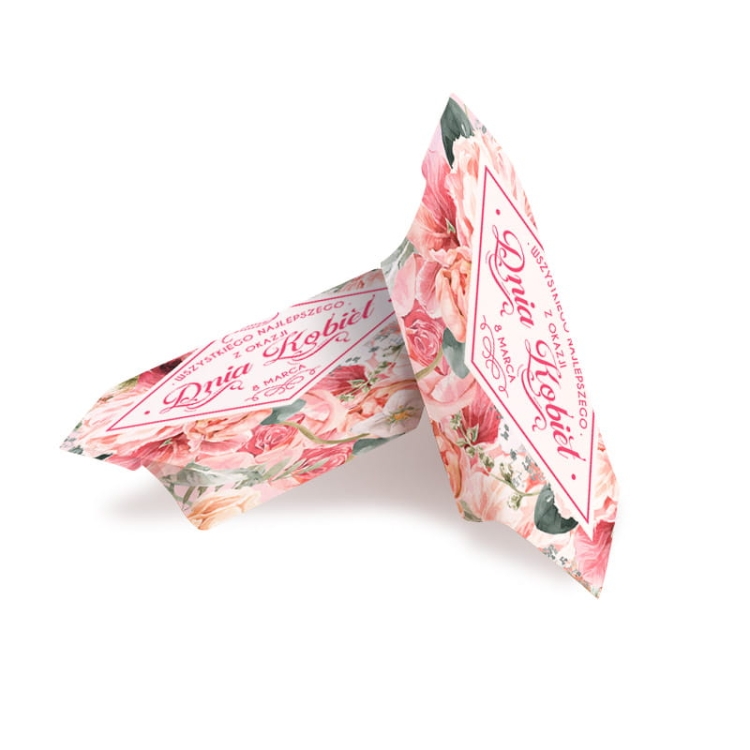 Pyszna krówka w ozdobnym papierku, na którym znajduje się napis Wszystkiego Najlepszego z okazji Dnia Kobiet 8 marca