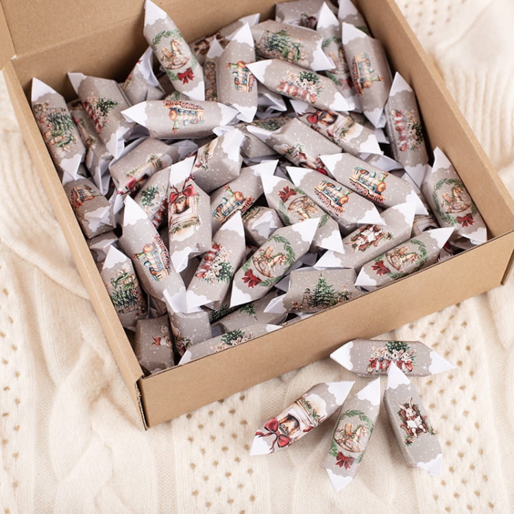 Pudełko z krówkami świątecznymi w ozdobnych papierkach.